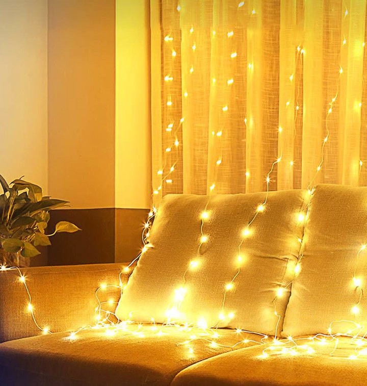Warm white curtain string lights in living room, creating a cozy and vibrant atmosphere.