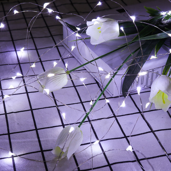Close-up of white curtain string lights, glowing softly for a cozy ambiance.