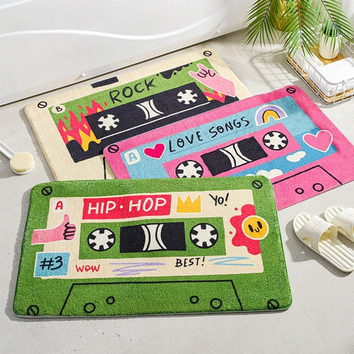 VibeCore Cute Cassette Accent Rug in pink, beige, and green, featuring a playful, retro cassette design. The rug combines vibrant colors and soft, plush texture to add a nostalgic touch to any space.
