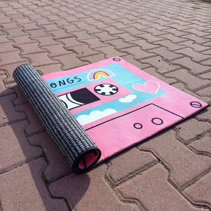 VibeCore Cute Cassette Accent Rug in pink, neatly rolled up to showcase its compact size and soft, plush material. The rolled-up rug reveals its vibrant design and high-quality texture.