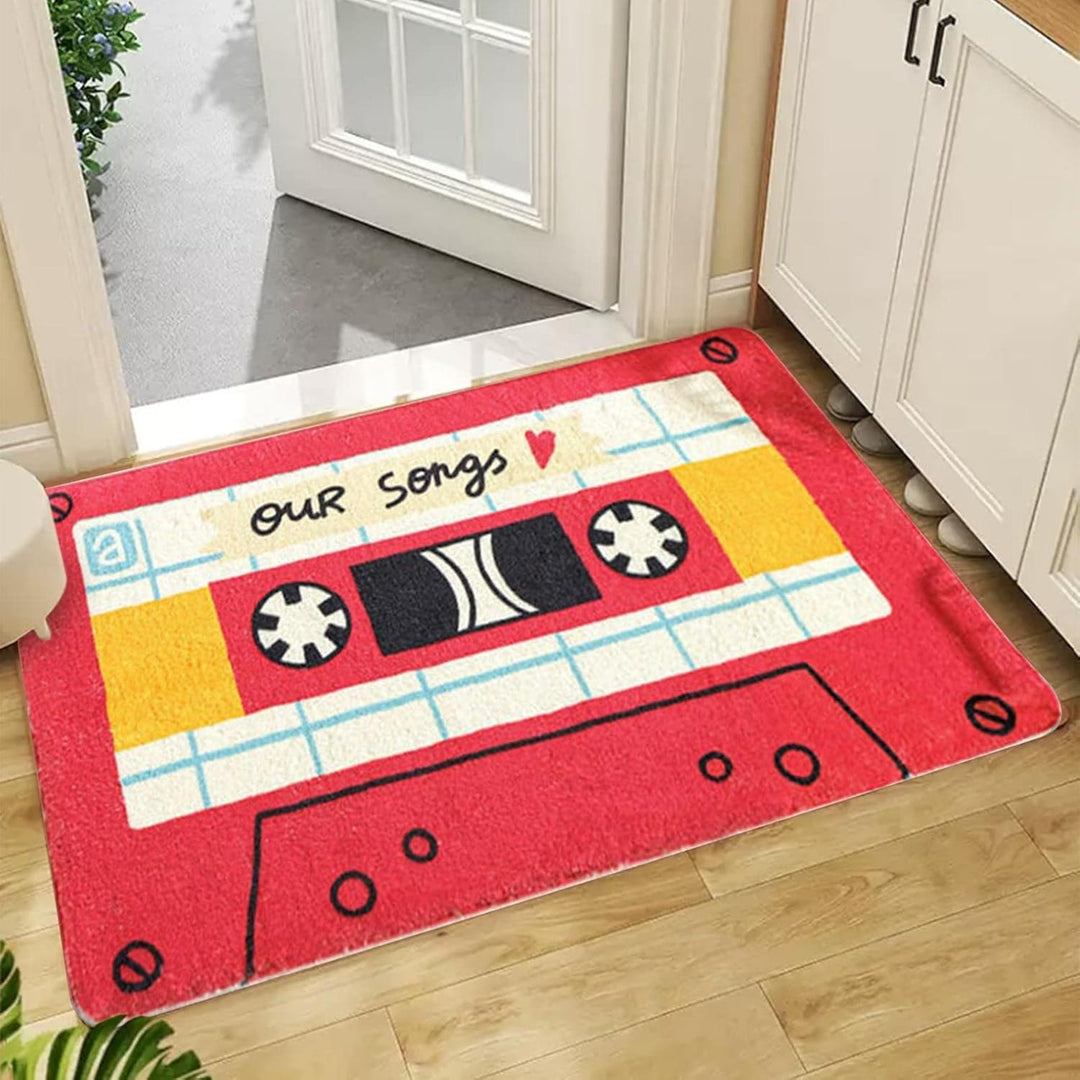 VibeCore Cute Cassette Accent Rug in red, placed in a doorway, featuring a bold retro cassette tape design. The soft texture and non-slip backing make it both stylish and practical for high-traffic areas.