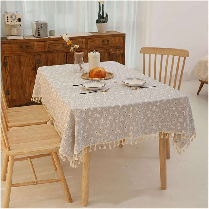 VibeCore Daisy Embroidered Linen Tablecloth in gray, placed on a table, highlighting the intricate daisy embroidery and soft, durable linen for a fresh and elegant look.