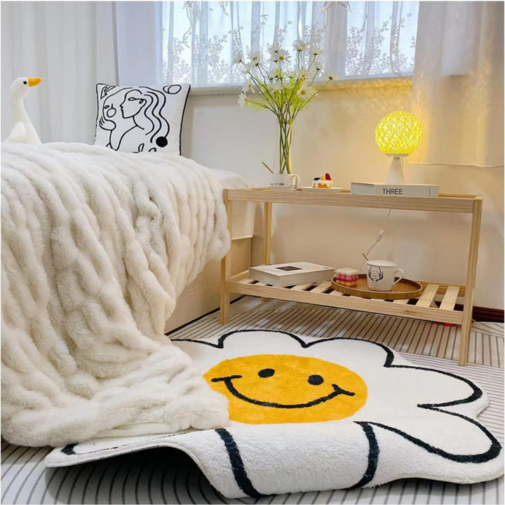 Close-up of the VibeCore Daisy Flower Accent Rug beside a bed in a bedroom, highlighting its playful smiling flower design, soft plush texture, vibrant colors, non-slip backing, and cheerful, cozy aesthetic. A cute, fun rug that adds personality, warmth, and a modern touch to bedroom, dorm, or living room decor.