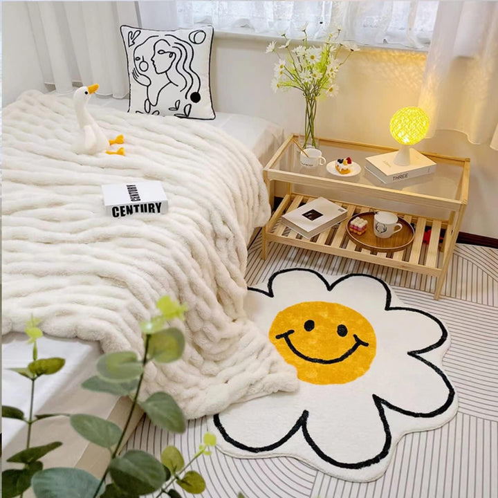 VibeCore Daisy Flower Accent Rug beside a bed in a bedroom, featuring its playful smiling flower design, soft plush texture, vibrant colors, non-slip backing, and cheerful, cozy aesthetic. A cute, fun rug that brings personality and a warm, inviting feel to modern bedroom, dorm, or living room decor.