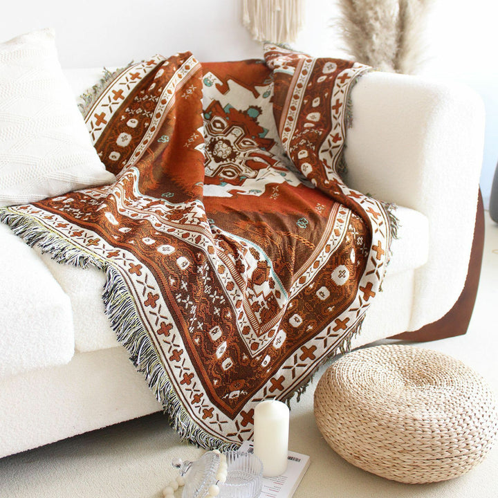 VibeCore Desert Mirage Woven Blanket draped over couch - reversible tribal cotton throw with bold boho pattern for cozy living room decor