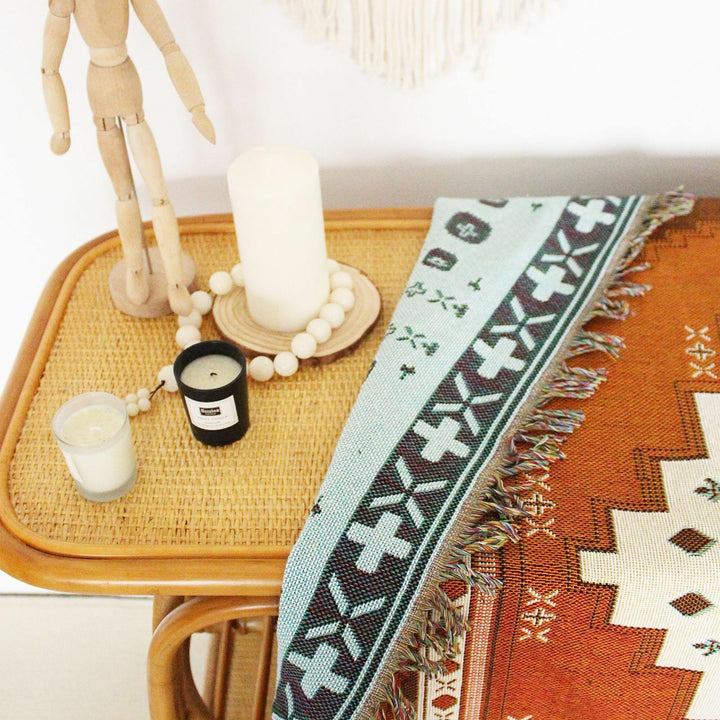 VibeCore Desert Mirage Woven Blanket Folded On Table, showcasing its reversible, vibrant design.