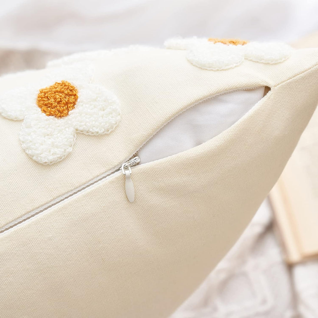 Close-up of the concealed zipper on white throw pillow covers with hand-stitched embroidered daisies. The sleek zipper design ensures a snug fit and polished look, complementing the soft, breathable cotton fabric and fresh floral embroidery.