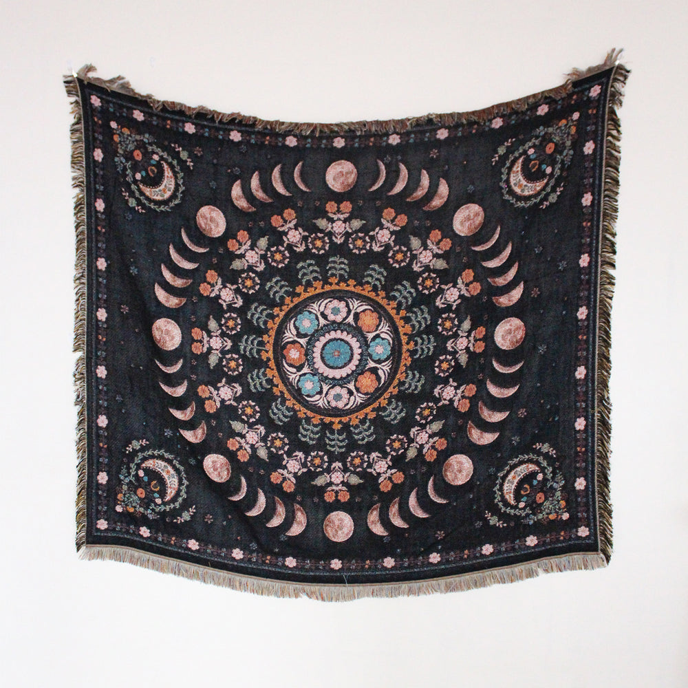 Floral Phases of the Moon Woven Blanket, showcasing its celestial and floral patterns. Made from 100% combed cotton, this versatile piece offers two reversible designs for added style and comfort.