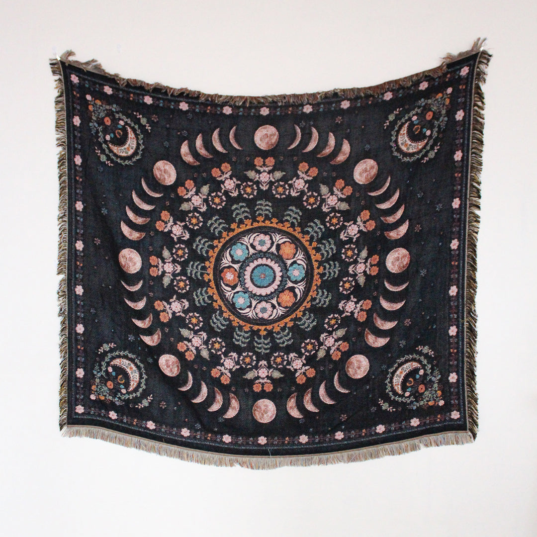 Floral Phases of the Moon Woven Blanket, showcasing its celestial and floral patterns. Made from 100% combed cotton, this versatile piece offers two reversible designs for added style and comfort.