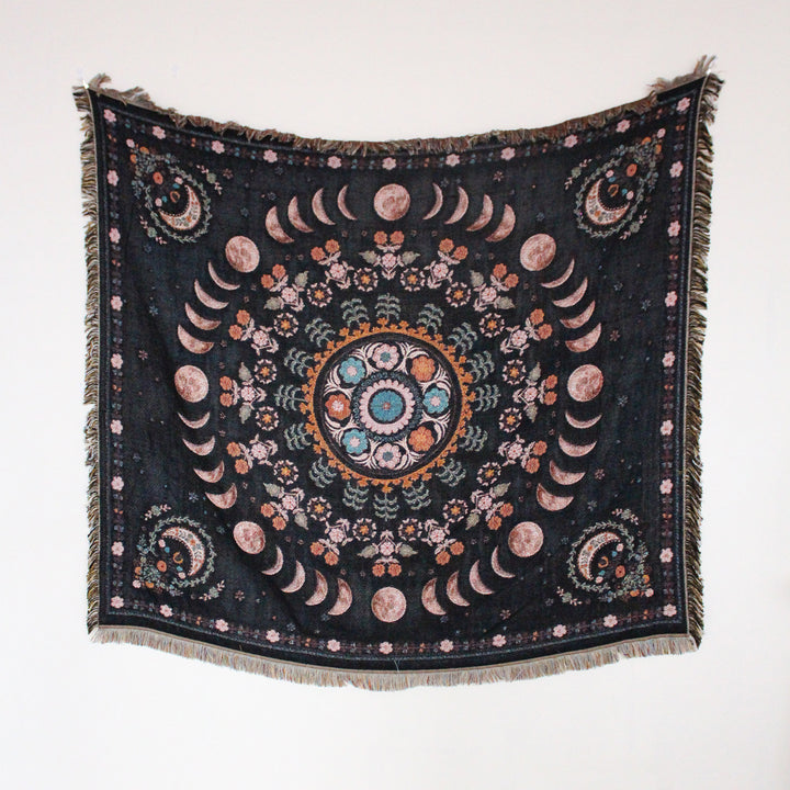 Floral Phases of the Moon Woven Blanket, showcasing its celestial and floral patterns. Made from 100% combed cotton, this versatile piece offers two reversible designs for added style and comfort.