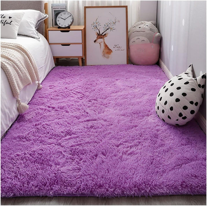 VibeCore Fluffy Area Rug in Purple placed beside the bed, adding a soft, plush texture and vibrant color to the bedroom decor.