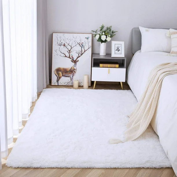 VibeCore Fluffy Area Rug in White placed beside a bed, adding warmth and comfort to the bedroom. The soft, plush texture complements the cozy, inviting atmosphere of the space.