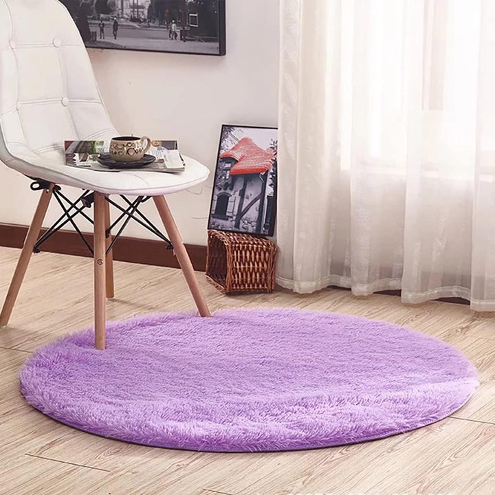 VibeCore Fluffy Round Area Rug in purple under a chair, featuring a soft plush texture and non-slip backing. Cozy and stylish, perfect for adding comfort to any space. Easy to clean and available in 8 colors.