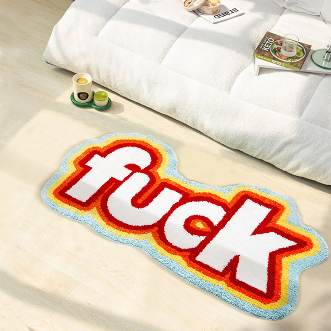 VibeCore Fuck Accent Rug beside a bed, showcasing its bold design and soft texture. The rug adds an edgy and rebellious flair to the bedroom while offering comfort with its plush feel and non-slip backing.