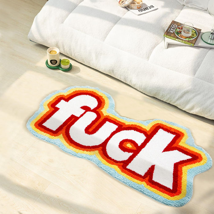 VibeCore Fuck Accent Rug beside a bed, showcasing its bold design and soft texture. The rug adds an edgy and rebellious flair to the bedroom while offering comfort with its plush feel and non-slip backing.
