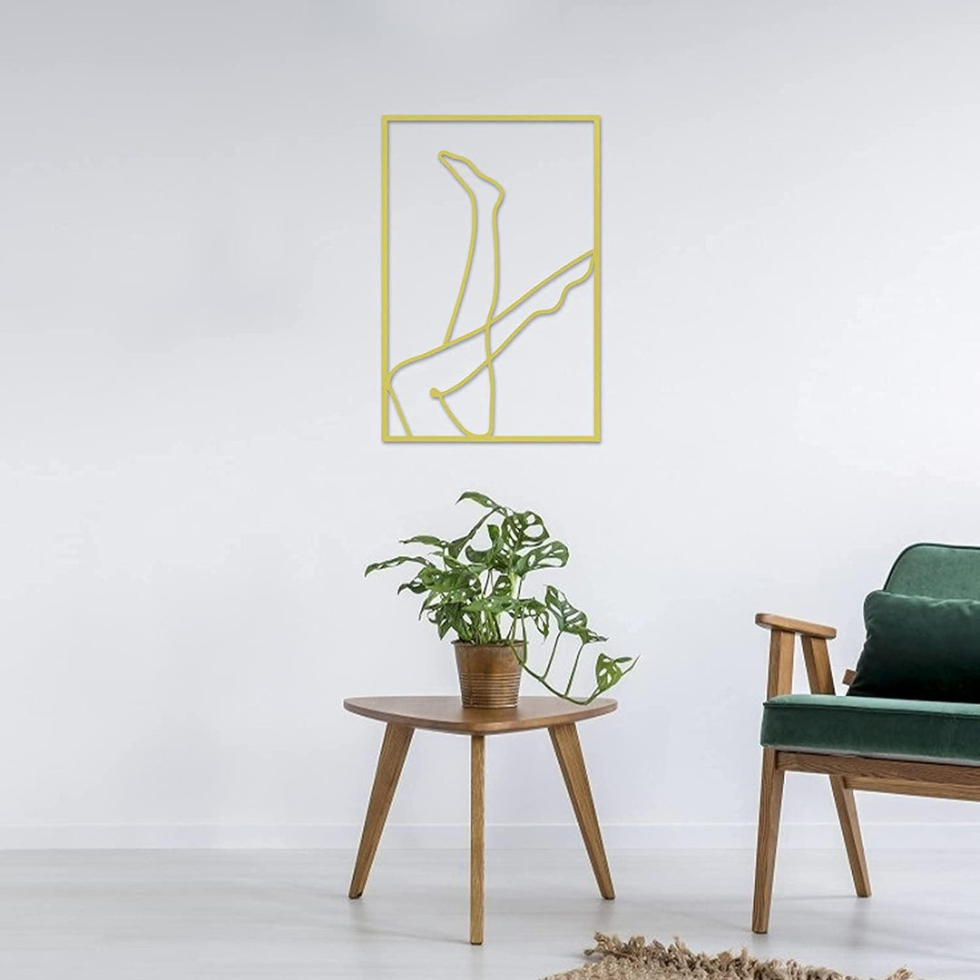 Gold female line art wall decor on living room wall – metallic gold acrylic silhouette of woman with legs in the air for modern living room, bedroom, or office – VibeCore minimalist aesthetic decor