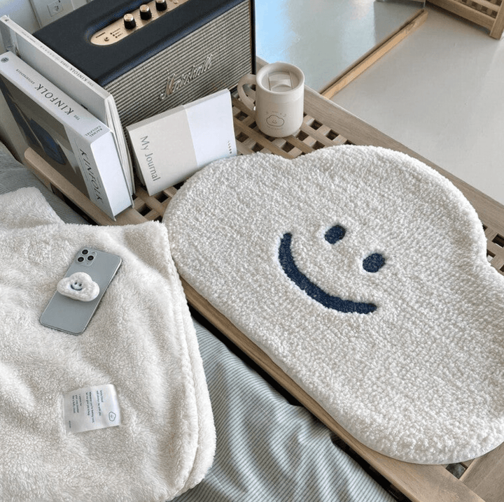 Aesthetic aerial view of the "Happy Cloud Accent Rug" on a bedroom floor, featuring an adorable cloud design with a cheerful face. This cute round rug adds a playful charm and positivity to the room, with a soft, plush texture and non-slip backing for comfort and safety. Perfect for any space in your home.