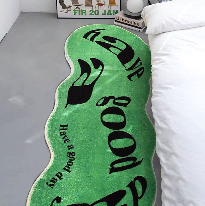 VibeCore Have A Good Day Trippy Accent Rug green beside a bed, showcasing its vibrant abstract design. The rug's bold colors and playful pattern add an energetic touch to the room. Its soft texture enhances the space, making it perfect for adding comfort and personality next to your bed. Ideal for bedrooms or dorm rooms, this rug brings a fun and lively vibe to your decor.