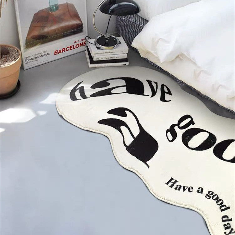 VibeCore Have A Good Day Trippy Accent Rug white, beside a bed, showcasing its vibrant abstract design. This rug adds a unique, aesthetic touch with an abstract text layout and a positive vibe, perfect for bedrooms, dorms, or spaces in need of a bold statement. Soft, plush texture enhances comfort while the trippy design elevates decor. Ideal for those who love urban or contemporary rugs with a quirky flair.