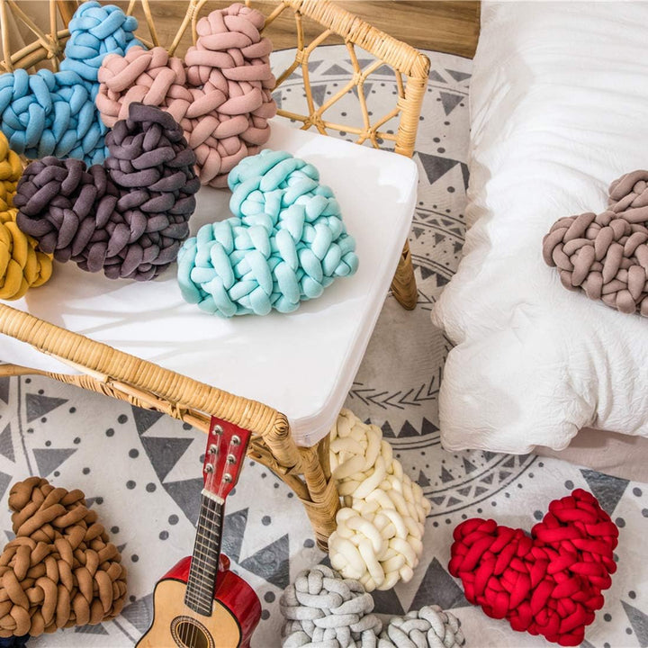 VibeCore Heart-Shaped Knot Throw Pillows in all colors, arranged in a bedroom, showcasing their heart-shaped, woven knot design. These plush, cozy pillows add a stylish and loving touch to your bed, creating a warm and inviting atmosphere.
