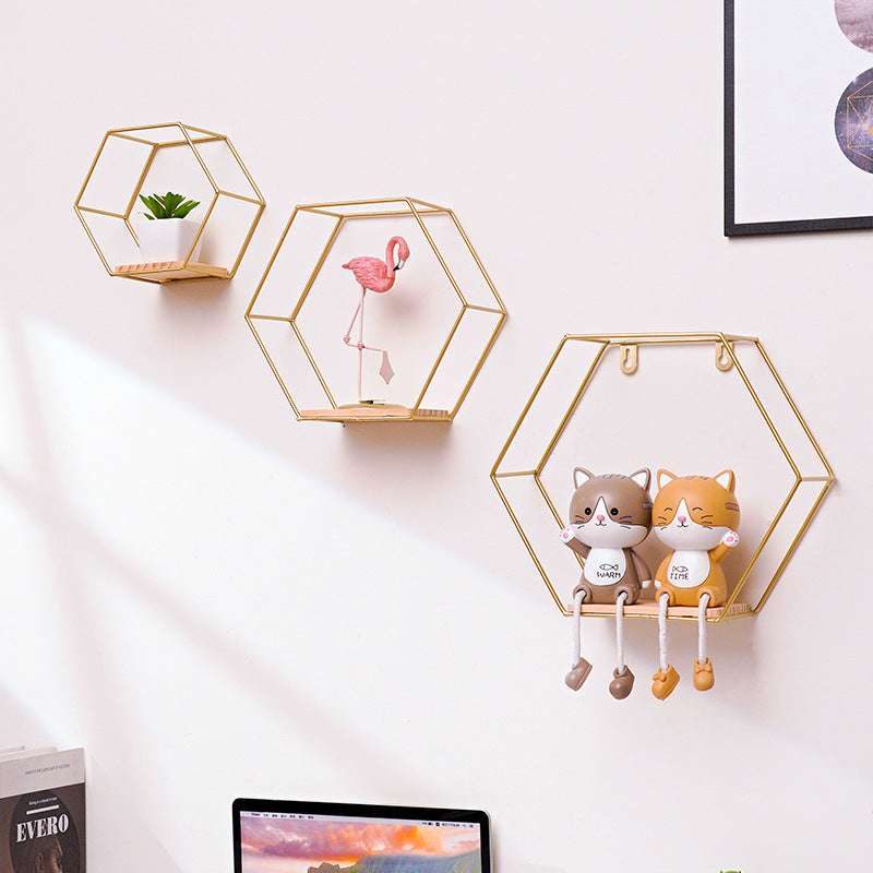 VibeCore Hexagonal Floating Wall Shelves in gold, displayed on a wall in three sizes, showcasing a mix of decorative items like plants and frames.