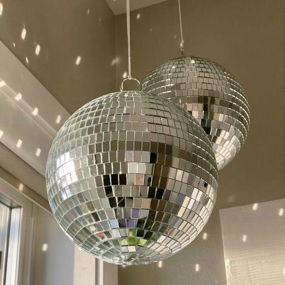 VibeCore Iconic Disco Ball close-up, hanging and reflecting light beautifully, creating a dynamic and vibrant atmosphere with its shiny mirror surface, perfect for adding sparkle to your space.