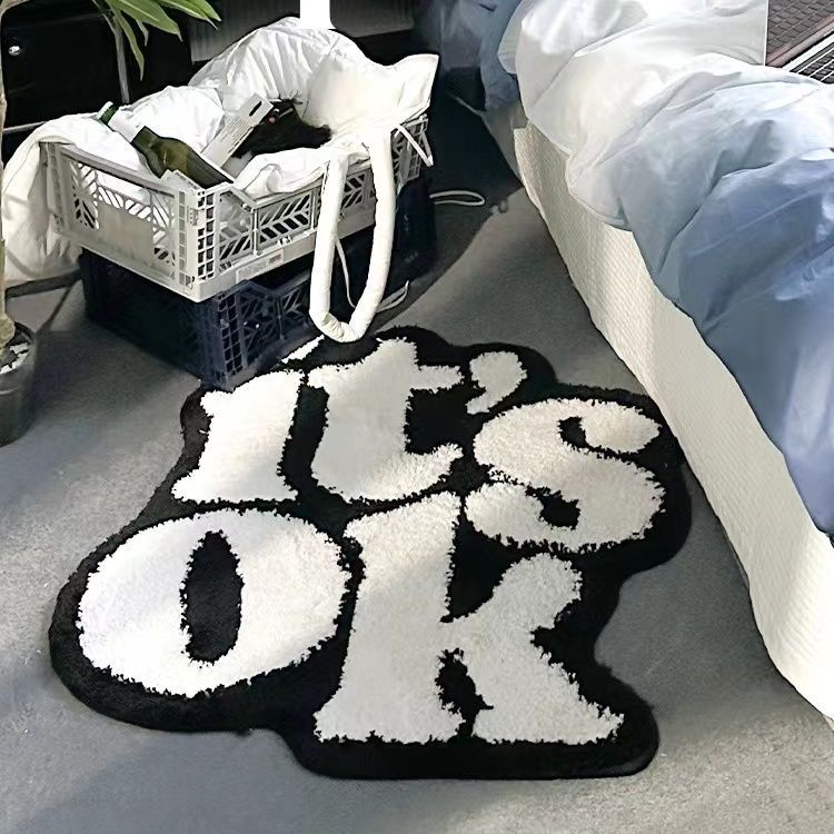VibeCore It's Ok Accent Rug Aerial View: Embrace tranquility with this minimalist black and white rug featuring a positive quote. Its clean, contemporary design adds a calm, stylish touch to any room. Ideal for bedrooms, living rooms, or dorms, this aesthetic rug enhances your space with a relaxed vibe and subtle urban appeal, complementing modern decor and adding comfort to your floors.
