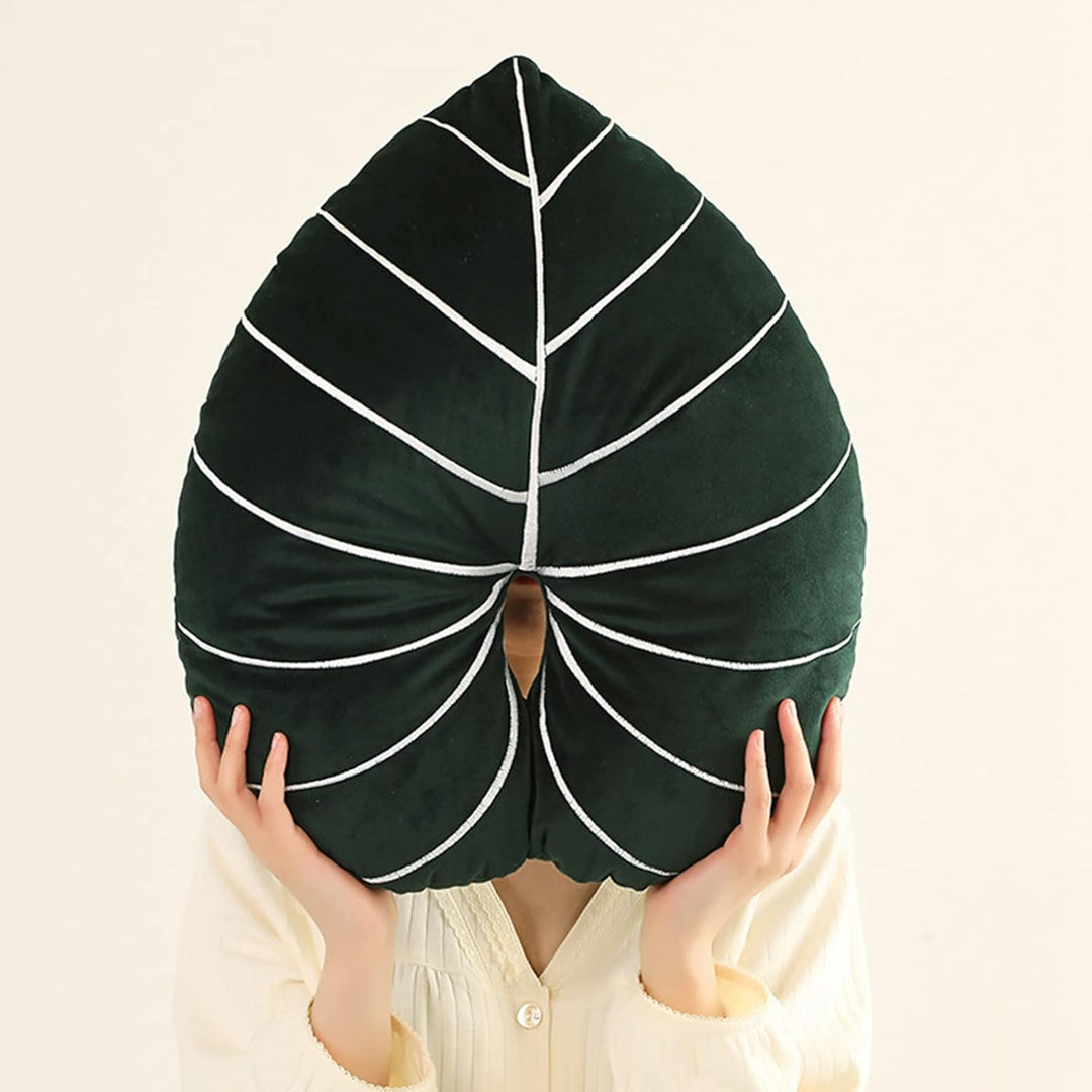 VibeCore Leaf Throw Pillow in Philodendron design, being held up to showcase its soft velvet plush texture and nature-inspired aesthetic. A perfect addition for adding a fresh, cozy vibe to any space.