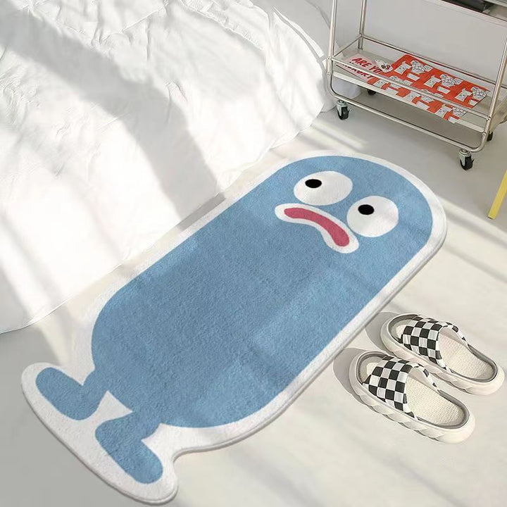 VibeCore Lil Blob Guy Accent Rug in blue with a frowny, quirky blob character in the center. This playful rug offers a soft, plush texture with a non-slip backing for stability. Perfect for adding personality and charm to any room, whether it’s a bedroom, living room, or dorm space.