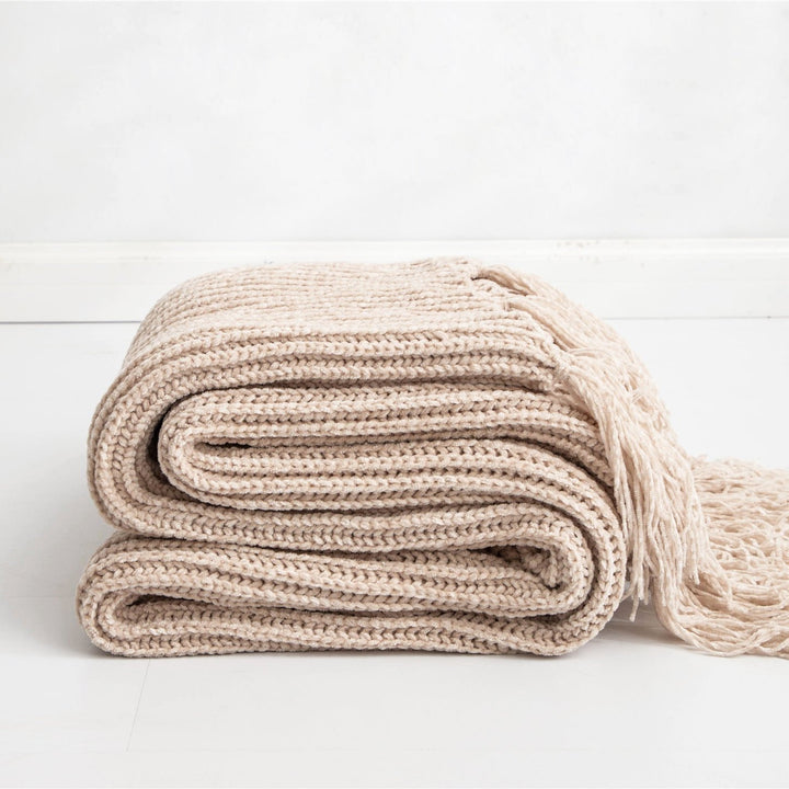 Beige Long Tassel Knitted Throw Blanket, offering a chic tassel design and ultra-soft comfort. Crafted from premium polyester, this cozy blanket adds texture and flair to any space. Perfect for dorm rooms, living rooms, or any cozy corner.