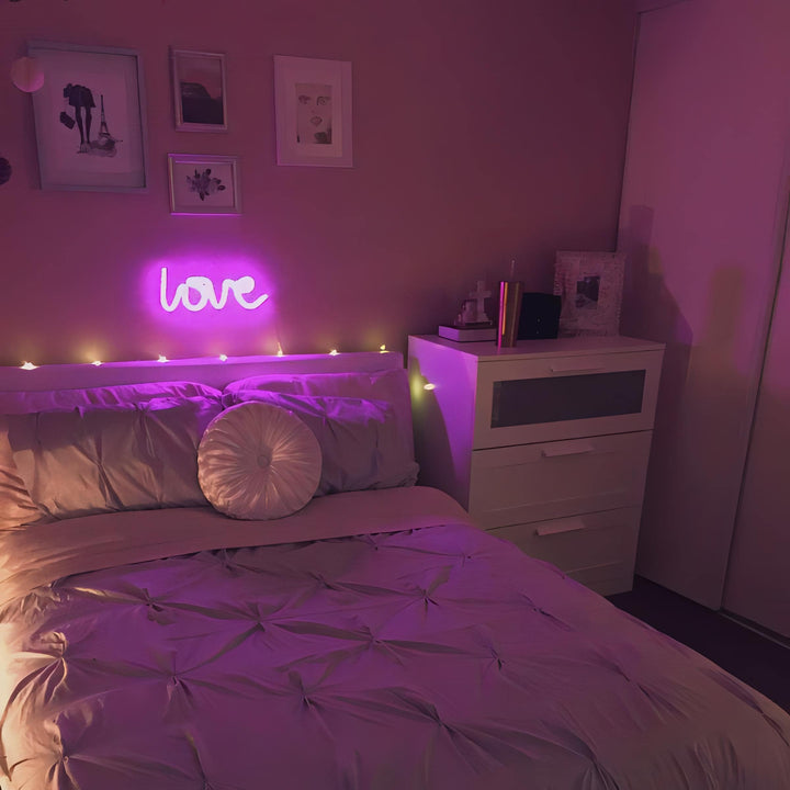 Aesthetic VibeCore Love Neon Light in pink on the wall above the bed, USB or battery-powered LED sign for trendy bedroom decor, creating a warm, romantic glow to elevate your space.