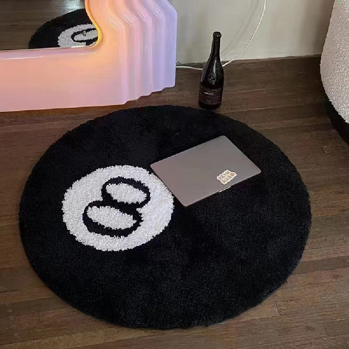 Close up view of the VibeCore Lucky 8 Ball Rug, showcasing its detail and soft, fluffy material. There is a laptop on it to show its size.