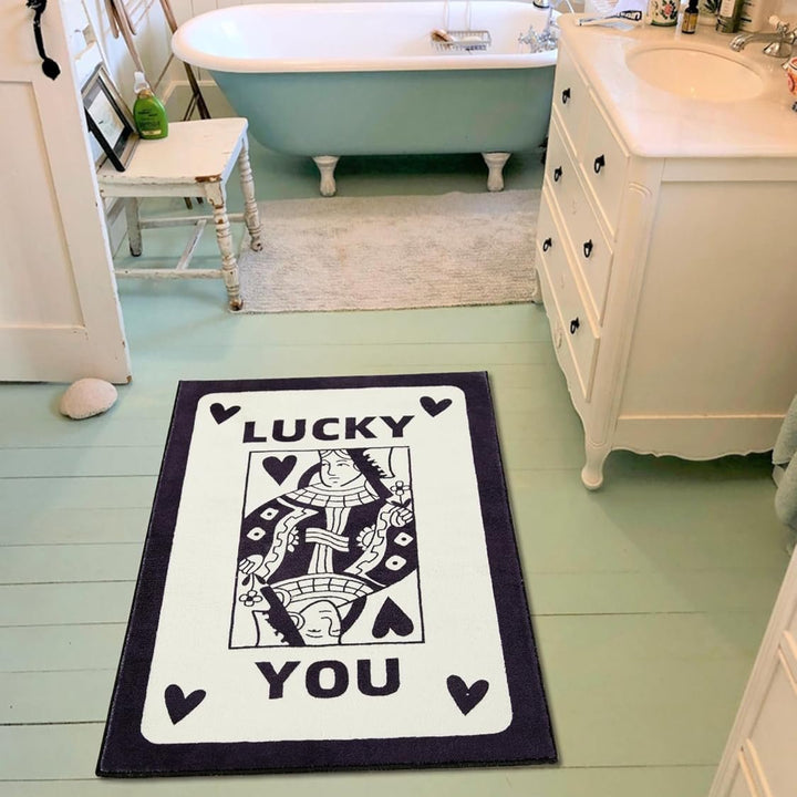 Aesthetic black and white "Lucky You" accent rug with a playful card design, styled in a bathroom. This soft, fluffy rug features a non-slip bottom for safety, making it perfect for adding a unique touch to your space while ensuring comfort and stability.