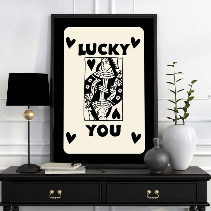 Lucky You Queen’ canvas poster displayed on a dresser, featuring a bold queen playing card design with black and gold details, adding a fun and retro-inspired touch to the space.