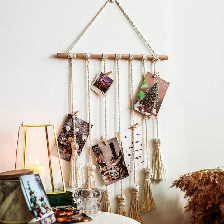 VibeCore Macrame Photo Wall Hanging Display on wall close up, featuring 30 wooden clips to hold photos, postcards, and prints, with a detailed boho design, ideal for personalized room decor.