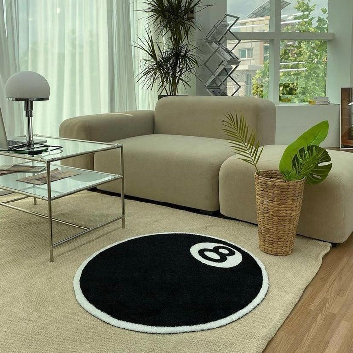 VibeCore Magic 8 Ball Accent Rug aerial view in a living room, showcasing the bold black and white 8 ball design. This playful round rug adds a fun, retro touch and complements modern decor with its unique, aesthetic vibe.