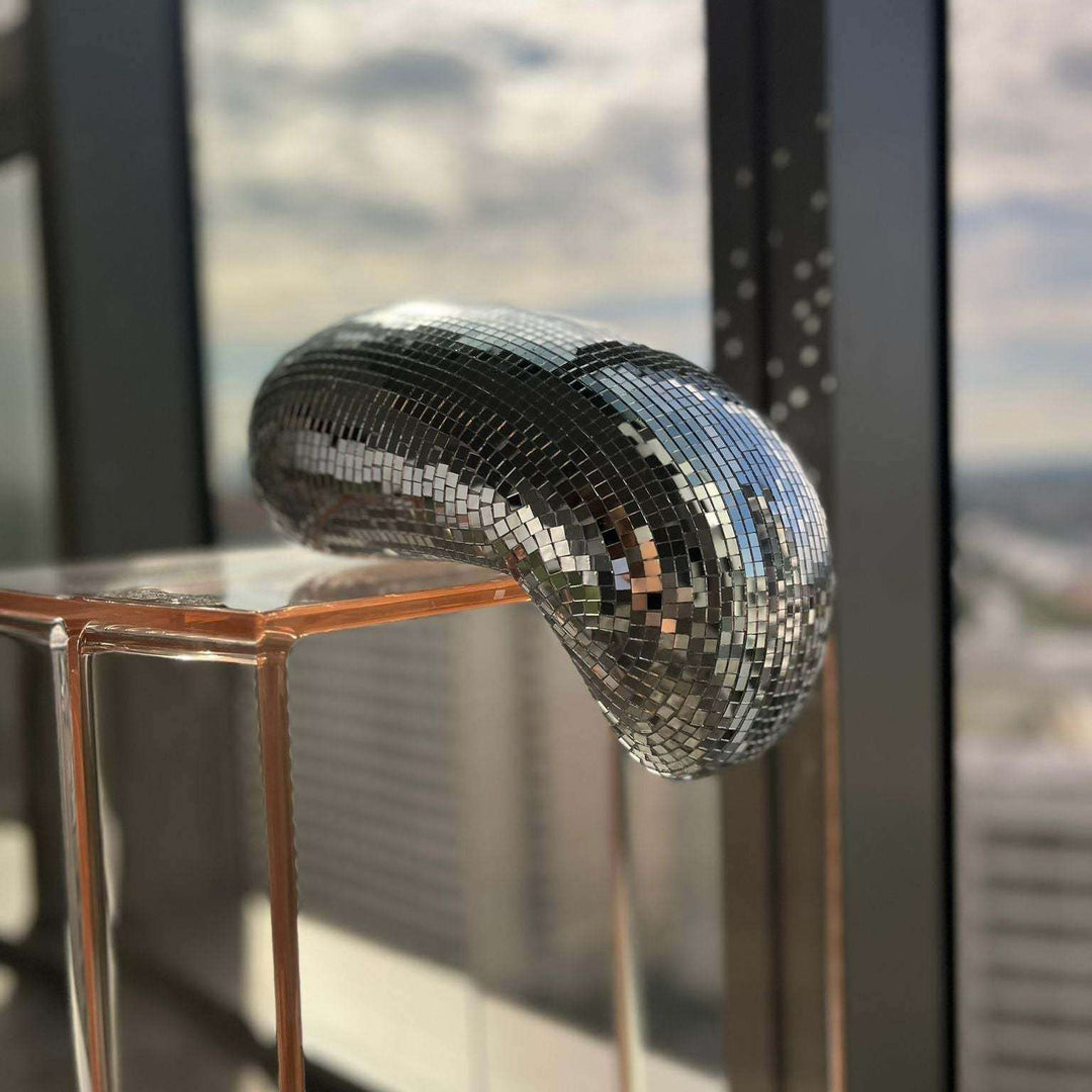 VibeCore Melting Disco Ball close-up by window, with natural light casting soft reflections on the surface.