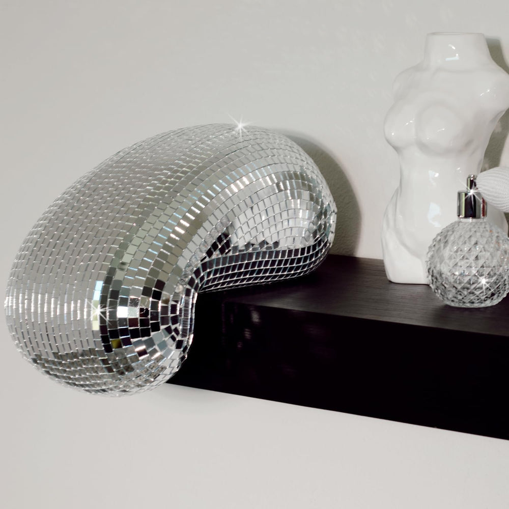 VibeCore Melting Disco Ball placed on a shelf, reflecting light and adding a playful, surreal touch to the decor.