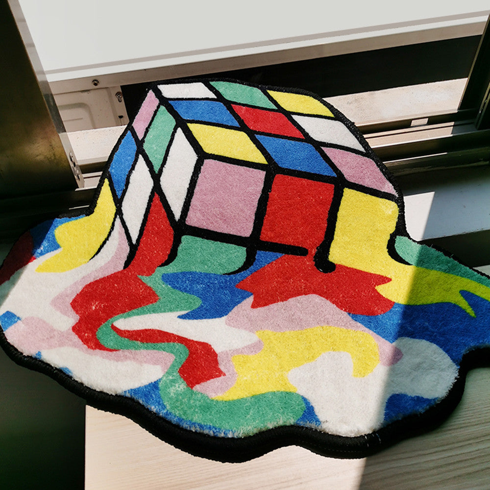 Close-up of the VibeCore Melting Rubik's Cube Accent Rug, featuring its vibrant, colorful melting puzzle design. The soft, plush texture adds comfort, making it a perfect, bold statement piece for modern bedrooms, dorms, or living rooms.