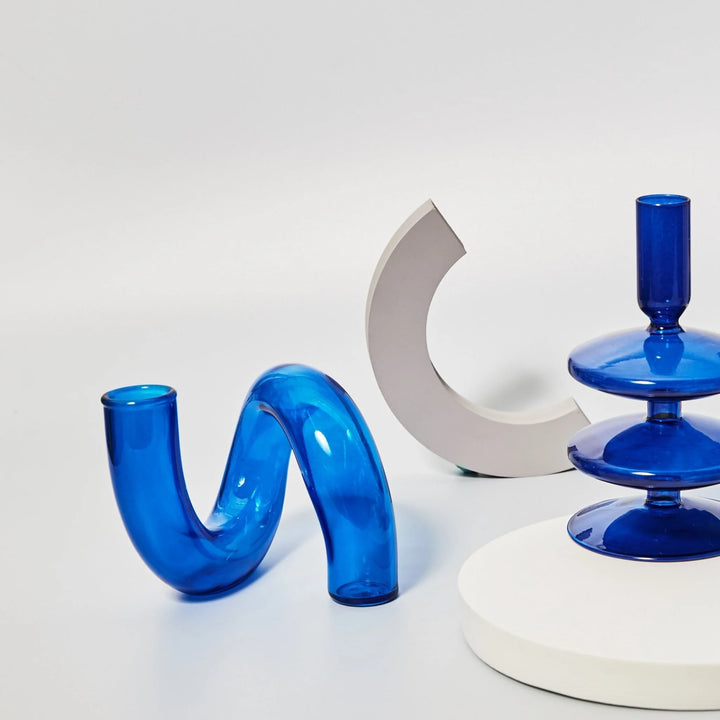 VibeCore Modern Twist Glass Candle Holder in blue, paired with other stylish decor items, adding a vibrant, minimalist touch to any space.