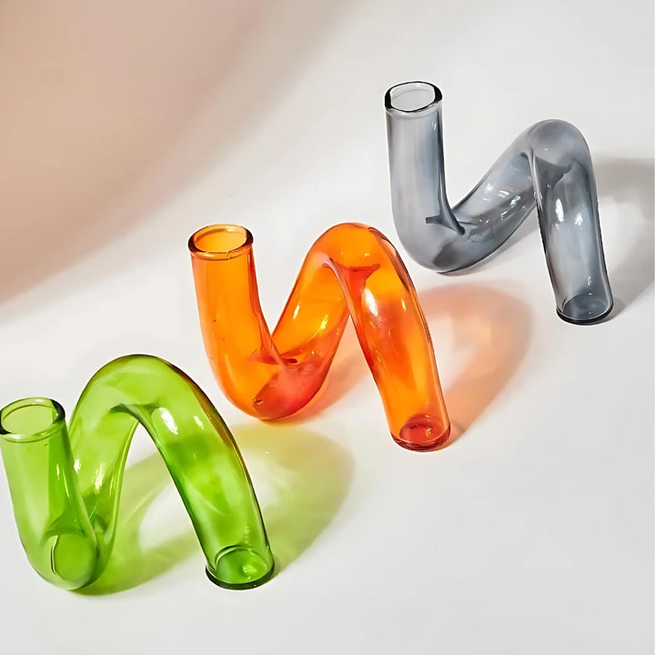 VibeCore Modern Twist Glass Candle Holders in green, orange, and gray borosilicate glass, featuring a modern twisted silhouette for minimalist home decor.