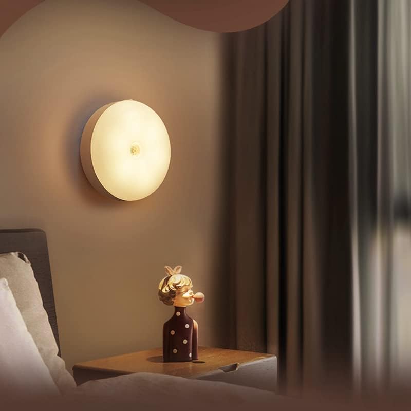 VibeCore Motion Sensor Puck Light in Warm White installed on a wall beside a bed - Modern motion-activated LED light with PIR sensor, 9.8 ft range, USB rechargeable battery, and versatile installation for cozy bedroom lighting.