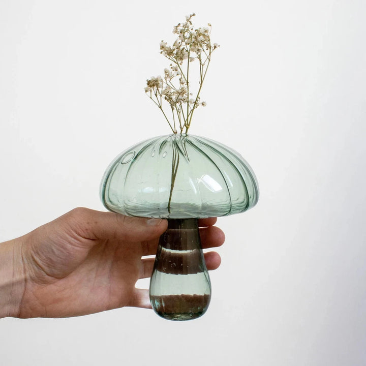 Mushroom Glass Vase in blue-gray with flowers inside, being held up, showcasing its unique design and vibrant floral arrangement.