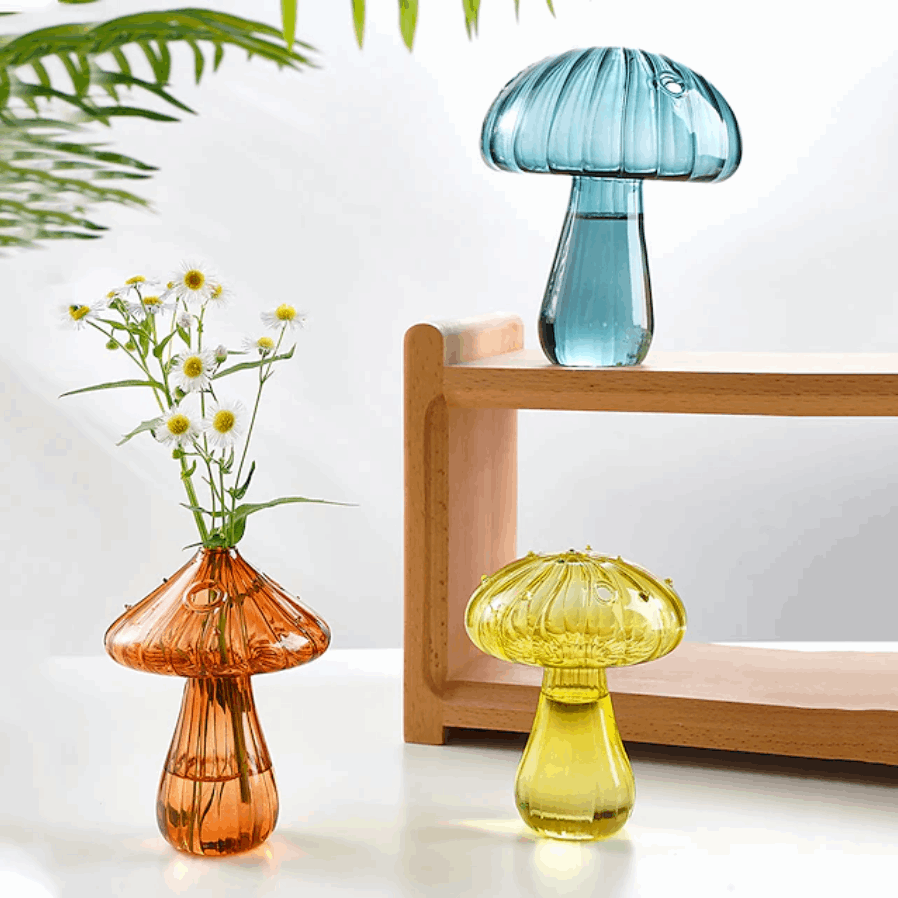 Mushroom Glass Vases in turquoise, brown, and yellow placed on a table, showcasing their vibrant colors and whimsical design.