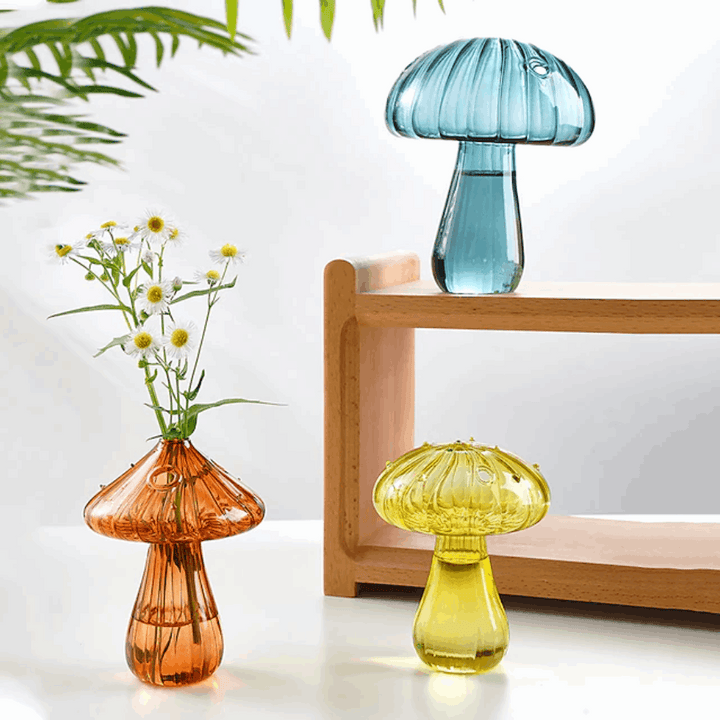 Mushroom Glass Vases in turquoise, brown, and yellow placed on a table, showcasing their vibrant colors and whimsical design.