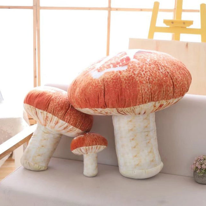 VibeCore Mushroom Throw Pillow in three sizes on a couch, showcasing the nature-inspired mushroom shape. Made from ultra-soft plush material and filled with PP cotton, these cozy pillows add a playful, fairycore touch to any room.