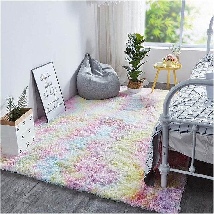 VibeCore Pastel Rainbow Tie-Dye Area Rug on floor beside bed, featuring vibrant pastel colors and a soft texture, enhancing the cozy and playful atmosphere of the room