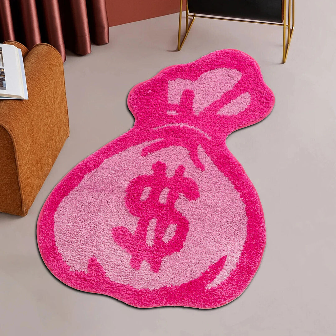 Top-down view of the VibeCore Pink Cartoon Money Bag Accent Rug, featuring a playful pink money bag design with bold, vibrant colors, ideal for girly, urban, and contemporary room decor. A cute rug for bedroom, dorm, living room, or hallway, it adds a quirky, fun vibe to any space. The soft, fluffy texture and non-slip backing make it both stylish and safe. Perfect for those who love unique, aesthetic rugs with a touch of humor and personality.