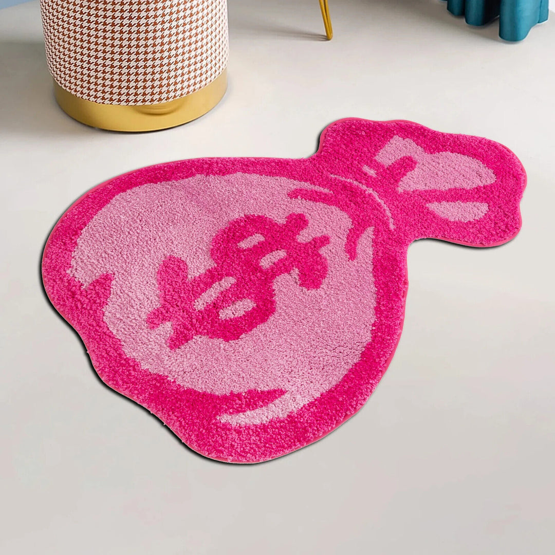 Side view of the VibeCore Pink Cartoon Money Bag Accent Rug, highlighting its cute money bag design and soft, plush texture. The rug’s vibrant pink color stands out, adding a quirky touch to any room. Ideal for modern spaces, this rug features a non-slip backing for added safety and comfort, making it perfect for bedrooms, dorm rooms, or living rooms.