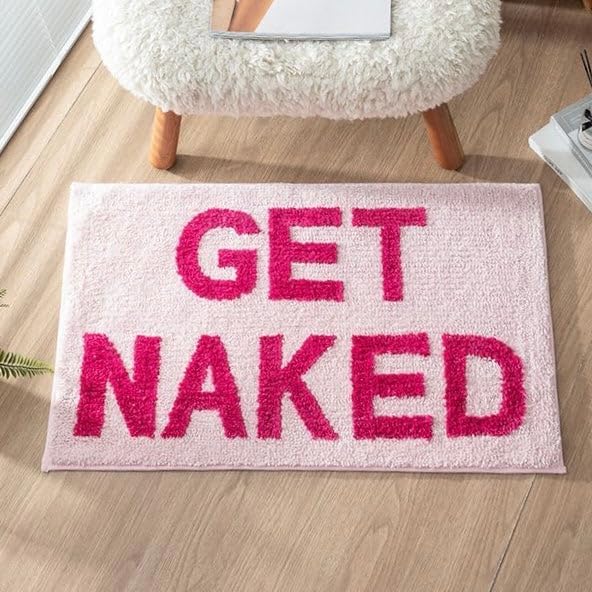 Aesthetic aerial view of the "Pink Get Naked Bath Mat," featuring a vibrant pink color and a cheeky, playful design. This soft, plush mat adds comfort and personality to your bathroom, with a non-slip backing for safety and stability, making it the perfect addition to any space.